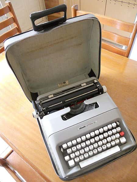 Vista do alto: Máquina de escrever portátil Letter 35 em capa de couro com mala aberta