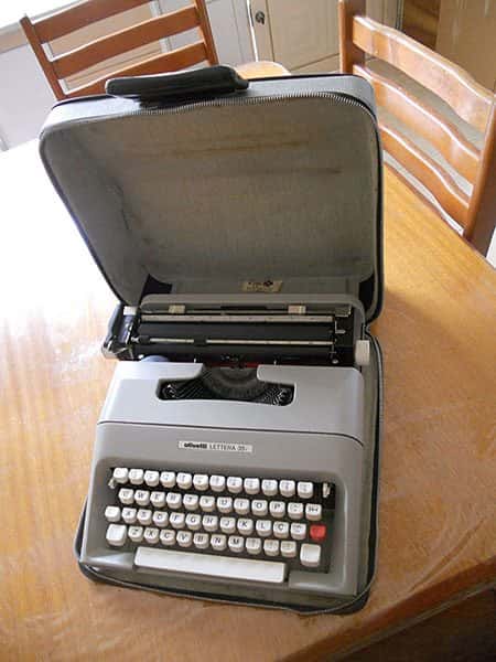 Vista diagonal superio: Máquina de escrever portátil Letter 35 em capa de couro com mala aberta,